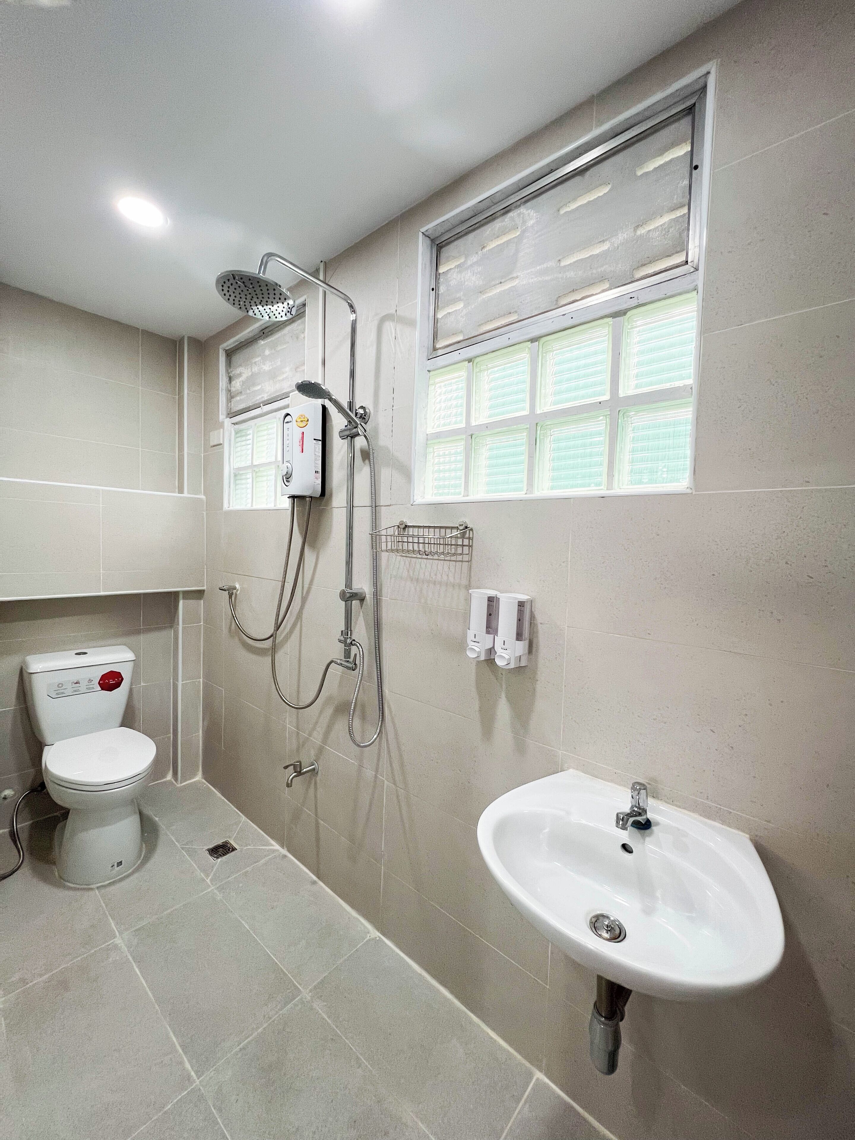 Un baño moderno con inodoro, ducha y lavabo.