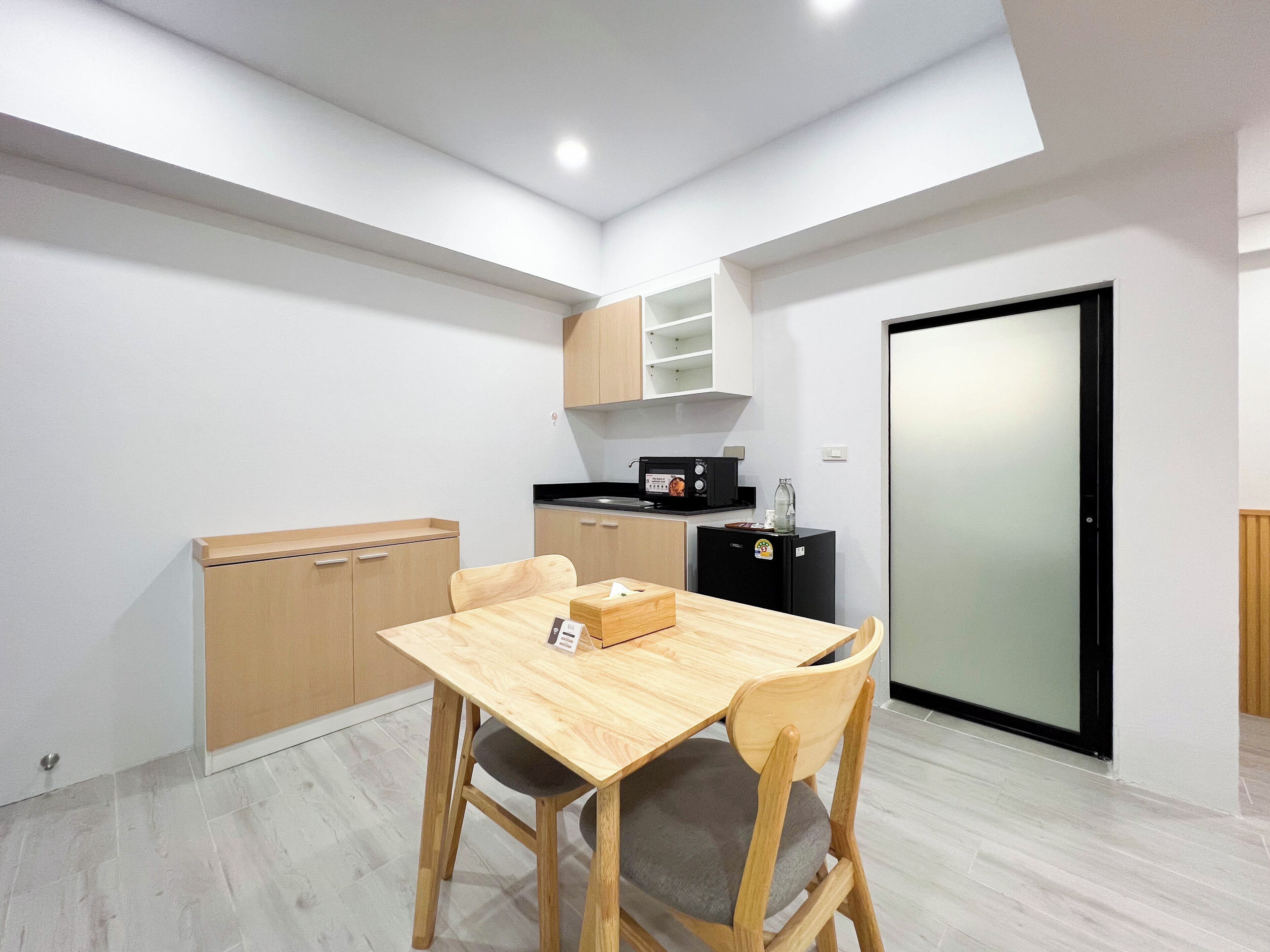 Une cuisine compacte comprenant une table et des chaises, un four à micro-ondes et un réfrigérateur.
