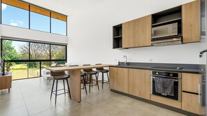 Una cocina moderna con un ventanal grande, armarios de madera y un horno empotrado.