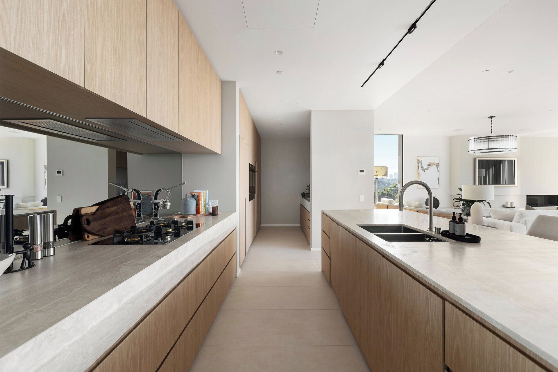 A modern kitchen with a long island, stainless steel appliances, and wooden cabinets.