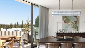 Un comedor moderno con una mesa grande, sillas y vistas al exterior.