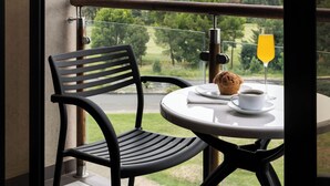 Ein Balkon mit Tisch, Stühlen und Blick auf die Landschaft.
