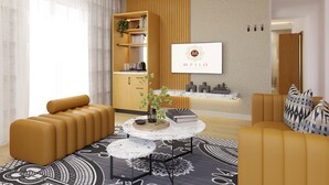Eine moderne Hotelhalle mit einem hölzernen Empfangstresen, einem großen gerahmten Logo und einer Sitzecke mit Sofas und einem Couchtisch.