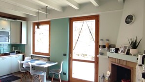 Eine moderne Küche mit Essbereich, großen Fenstern und einem Kamin.
