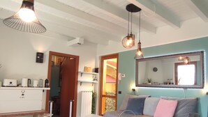 Ein gemütliches Wohnzimmer mit einer Couch, einer Kaffeemaschine und einem großen Spiegel.