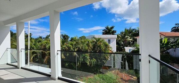 Enjoy unobstructed views of lush greenery and palm trees from this spacious balcony.