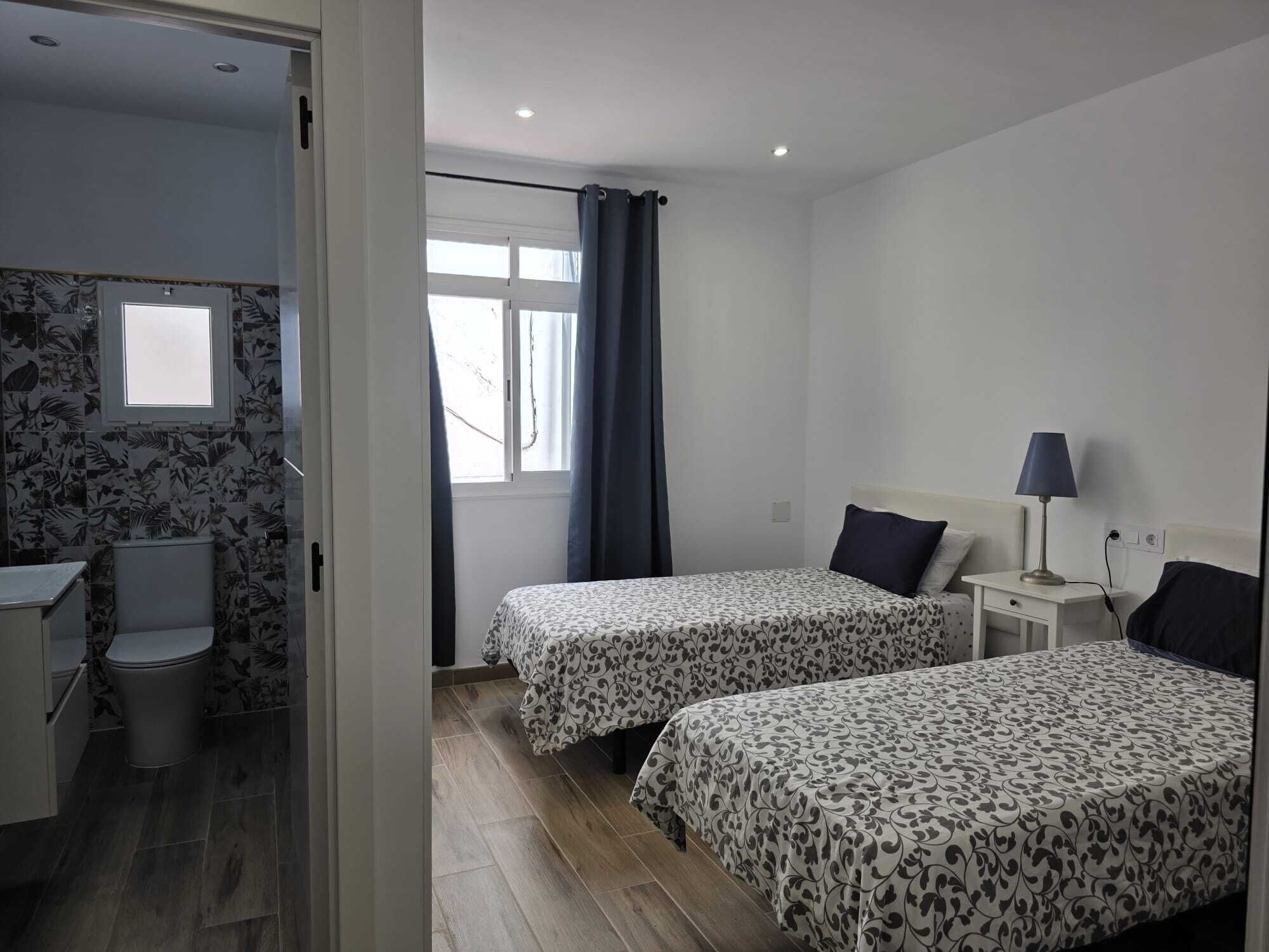 Ein Schlafzimmer mit zwei Betten, einem Schreibtisch und einem Stuhl.