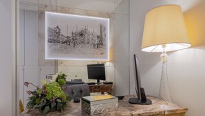 A marble desk with a glass-top, a black monitor, a lamp, and a framed black and white cityscape. - Cà dell'Arte Boutique (Venice)