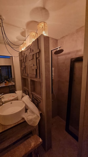 A bathroom with a sink, mirror, and shower.
