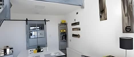 A modern interior with a dining area, a loft space, and a kitchen.