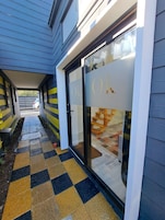 A building entrance with a checkered tile path leading to a glass door with 'Ok Loft' signage.