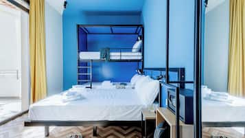 Ein Zimmer mit einem Etagenbett, einem Schreibtisch inklusive Computer und einem Fenster mit Vorhängen.
