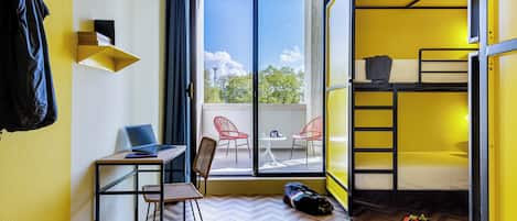 Habitación pequeña con escritorio, silla y literas.