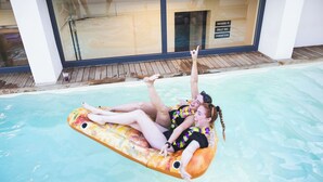 Una piscina con un pontile in legno e una parete in vetro.