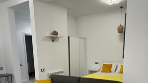 Ett modernt vardagsrum med en grå soffa, ett vitt soffbord och en gul prydnadskudde.
