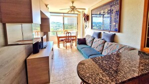 Una cocina moderna con comedor, ventilador de techo y un amplio ventanal con vistas al campo.
