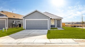A modern two-story house with a grey garage, a small porch, and a well-maintained lawn. - *NEW* The Boho Bungalow | 20%  Discount | BOOK NOW (New Braunfels)