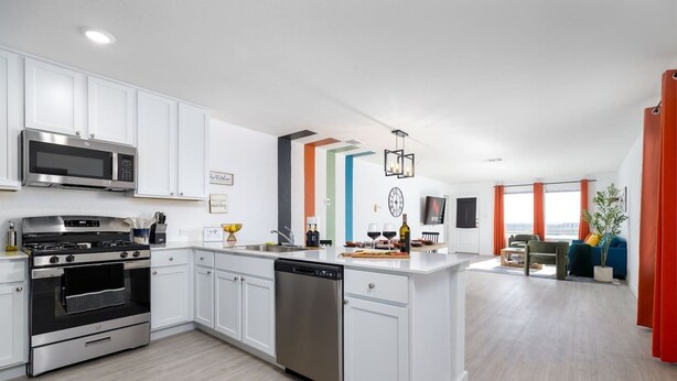 A modern kitchen with white cabinets, stainless steel appliances, and a central island. - *NEW* The Boho Bungalow | 20%  Discount | BOOK NOW (New Braunfels)