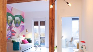 A modern living room with a sofa, a small table, and a mural on the wall. - Apartamento Kursal by SanSe Holidays (Donostia)