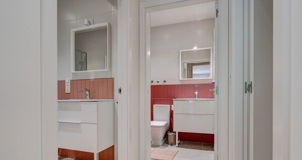 Et moderne badeværelse med bruser, toilet og håndvask.