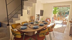 Un coin repas avec une table ronde dressée pour six personnes, entourée de six chaises.
