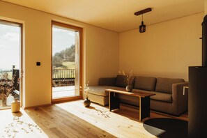 Relax in this serene living space with a sliding door leading to a deck overlooking the natural landscape.
