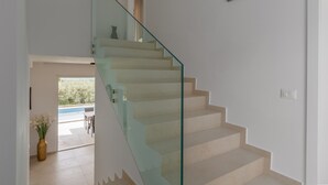 A modern staircase with glass railings leading to an upper floor.