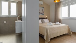 A modern bedroom with a bed, bedside table, and a painting on the wall.