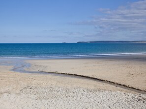 Ein Strand mit sandigem Ufer und ruhiger See.