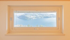 A window with a view of a lake and a distant island.