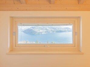 Une fenêtre donnant sur un lac et une île lointaine.