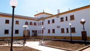 A courtyard with a white building, benches, and street lamps. - Turismo rural Valsequillo (Valsequillo)