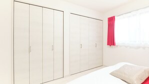 A bedroom with a bed, a wardrobe, and a window with curtains. - Flora Maison Kamiochiai by Tranova (Tokyo)