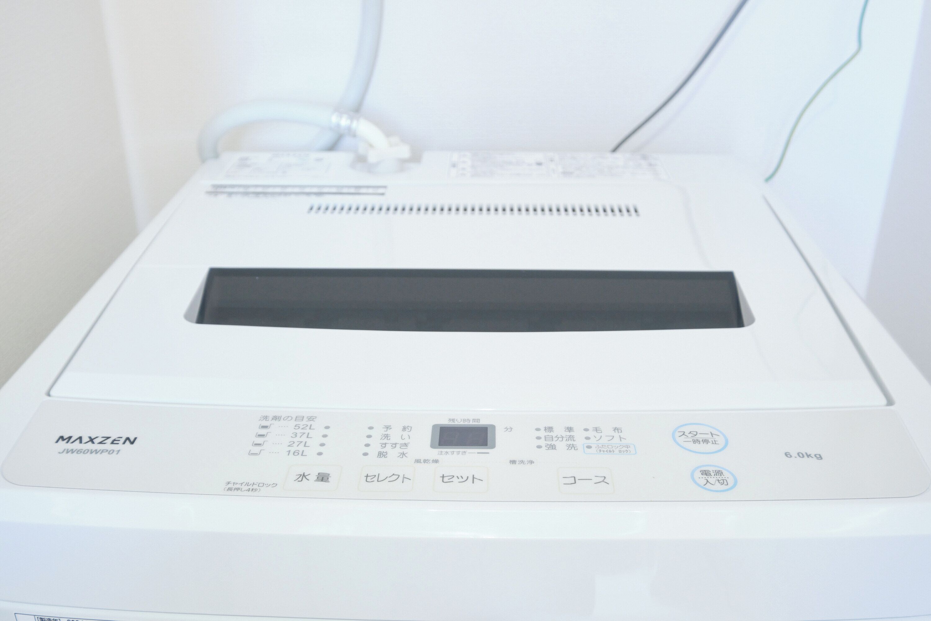 Um eletrodoméstico MAXZEN JW60WP01 branco com visor digital, painel de controle e indicador de peso de 6,0kg.