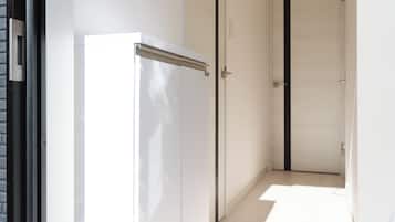 Un corridoio con una porta bianca, un telaio nero e un pavimento chiaro.