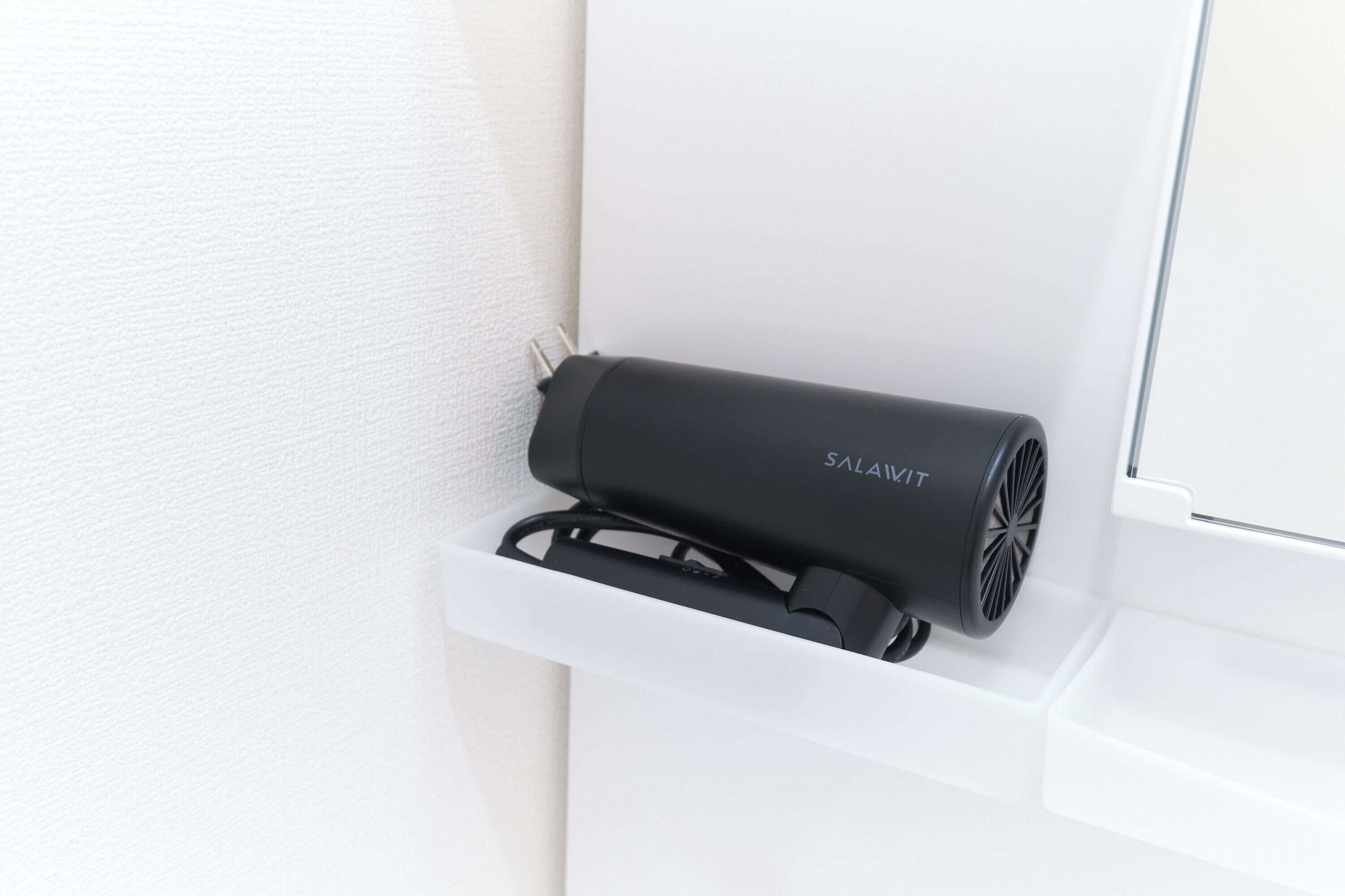 A black device labeled "SALAIKIT" mounted on a white wall, likely a security or control panel.
