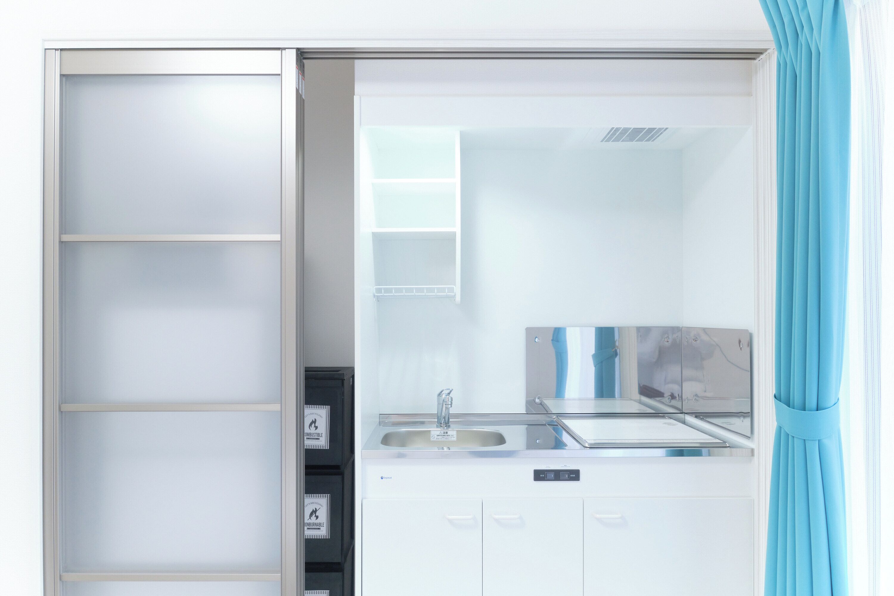 A modern bathroom with a glass shower enclosure, a sink, and a mirror.