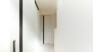 A narrow hallway with a white door at the end. - Flora Maison Kamiochiai by Tranova (Tokyo)