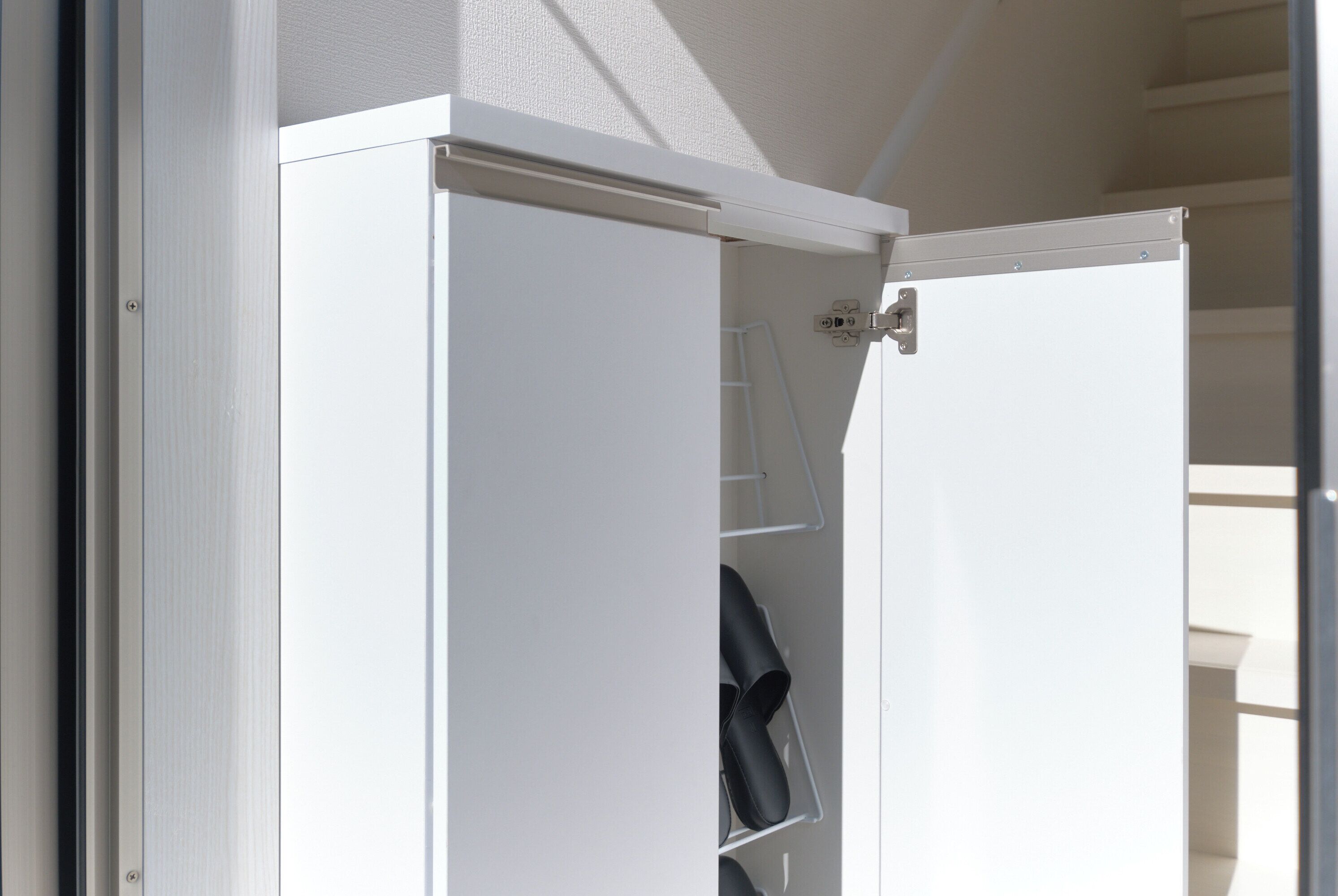 A white door with a metal handle and a small shelf with a black item on it.