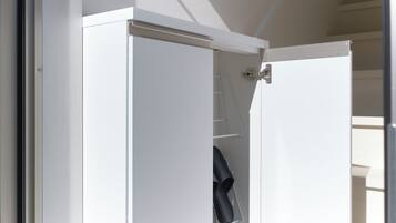 A white door with a metal handle and a small shelf with a black item on it.
