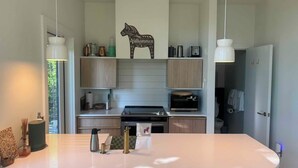 Une cuisine moderne dotée d’un îlot central, de meubles en bois et d’un élément décoratif mural.