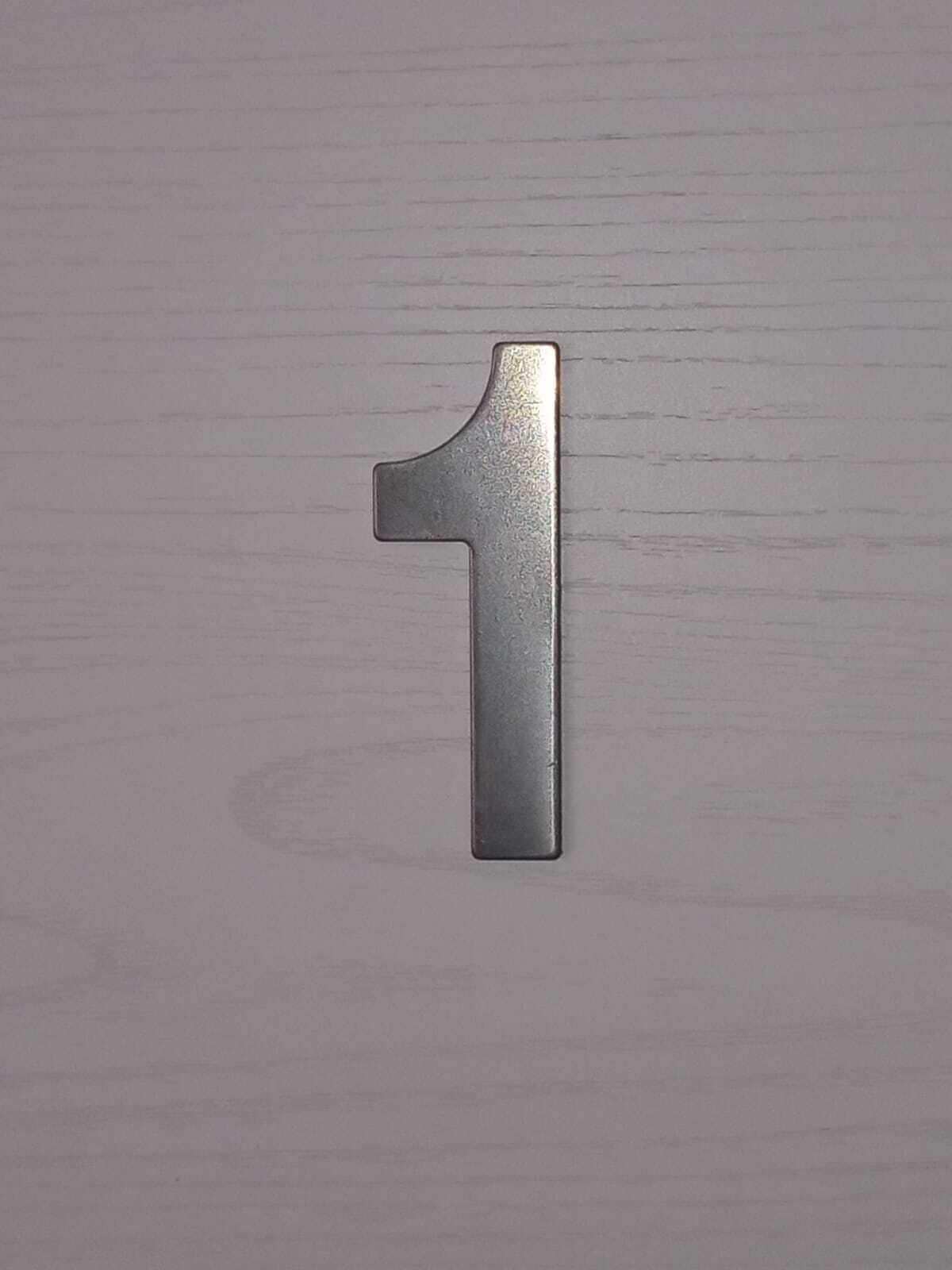 A metallic number 1 on a textured surface.