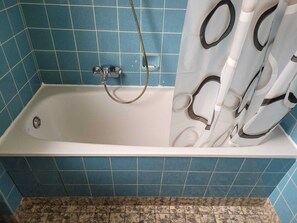 Tina y regadera independientes, toallas, jabón, papel de baño