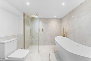 A modern bathroom with a glass-enclosed shower, a freestanding bathtub, and a toilet. - Experience Elegance in Central Bath (Bath)