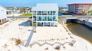 A modern multi-story building with large windows, located near a beach and a waterway. - Just Beachy (Port St. Joe)