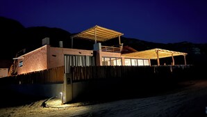 Una casa moderna con un porche cubierto y una fuente de luz en el suelo.