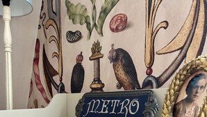 A white dresser with a small tray on top, a lamp, and a decorative item with the word "METRO" on it.