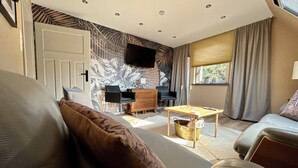 A modern living room with a sofa, a coffee table, and a TV mounted on the wall.