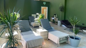 A sunlit patio area with wicker furniture, potted plants, and a view of the building's interior. - The Jewel Lodge and Spa (Glengarriff)