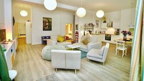 Una sala de estar moderna con un sofá, sillones y un comedor con mesa y sillas.